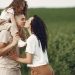 A heartwarming family moment captured in a field, highlighting love and togetherness.